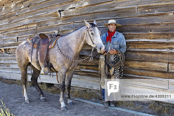Cowboy mit Pferd vor Scheunenwand  Wilder Westen  Oregon  USA