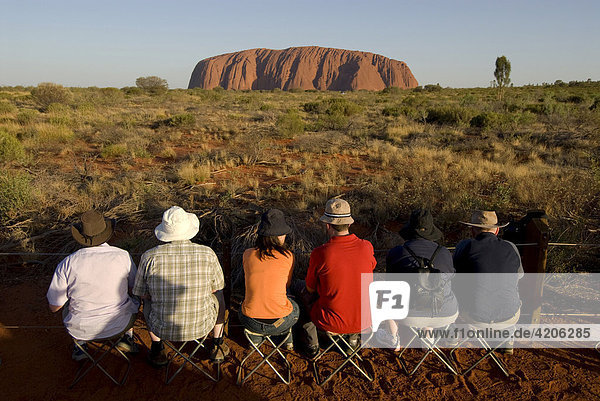 Magischer Felsen der Aboriginals ist der Monolit Ayers Rock  genannt Uluru  Touristen warten auf den Sonnenuntergang  Uluru - Kata Tjuta Nationalpark  Northern Territory  Australien