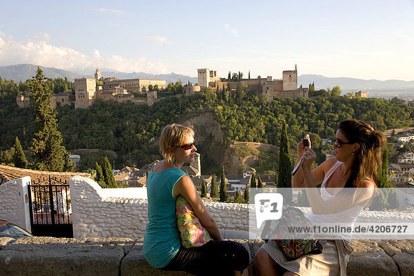 Touristinnnen fotografieren sich am Mirador de San Nicolas  Alhambra: maurische Stadtburg  Nasriden Paläste  Palast Karl des Fünften  Granada  Andalusien  Spanien