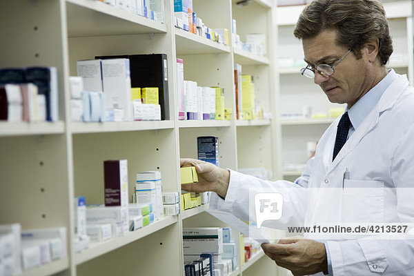 Pharmacist checking shelf for medication