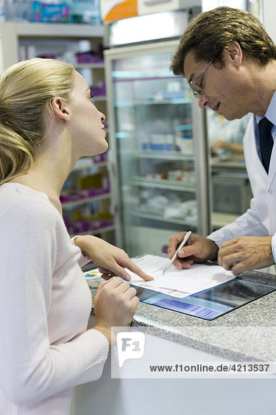 Pharmacist explaining prescription to customer