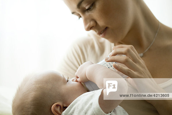 Mutter füttert Kleinkind mit Babyflasche