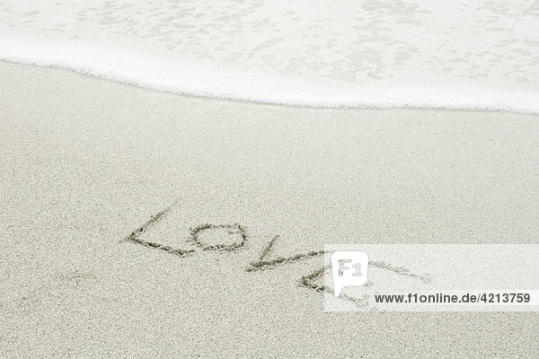 'The word ''love'' written in the sand at the beach'