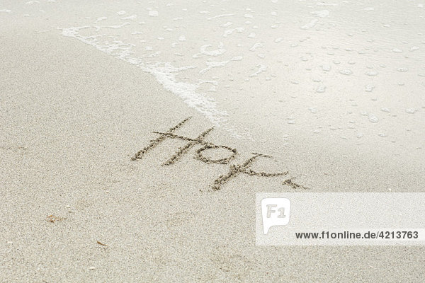 'The word ''hope'' written in the sand at the beach  partially washed away by the tide'