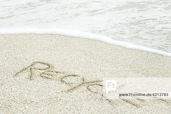 Das Wort recyceln   geschrieben im Sand am Strand .