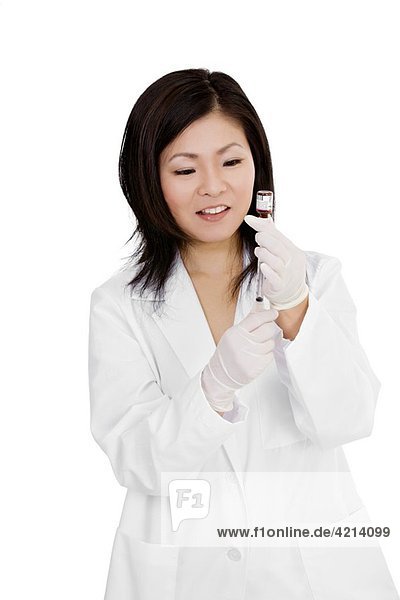 Beautiful Asian doctor or nurse preparing a vaccination