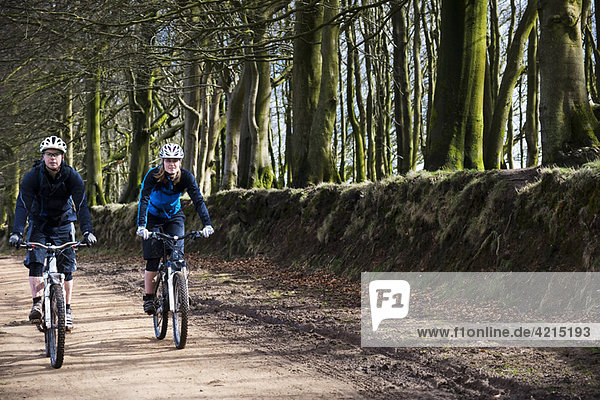 Couple mountain biking in countryside