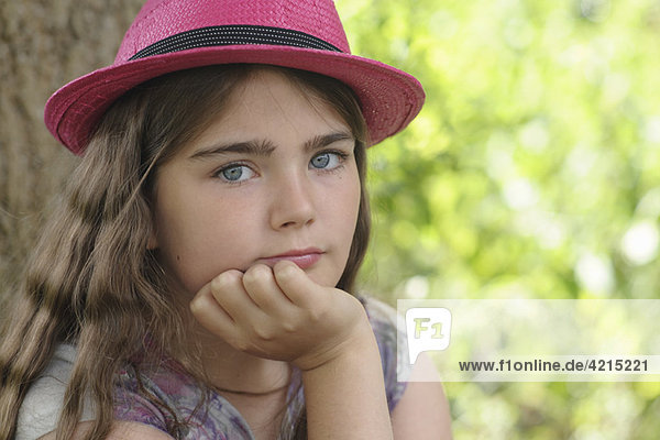 Porträt eines jungen Mädchens mit rosa Hut