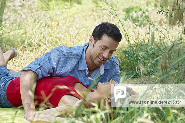 Romantisches Paar im langen Gras liegend