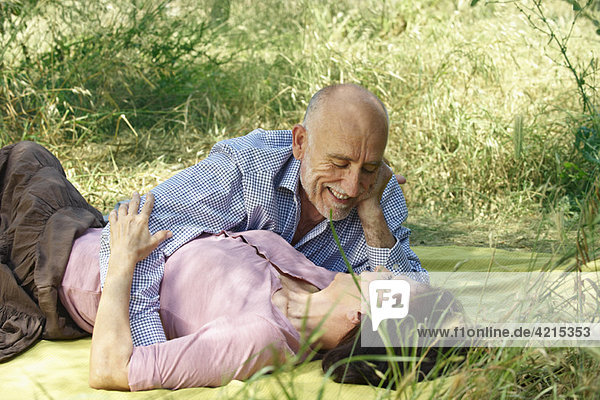 Older couple embracing on picnic blanket