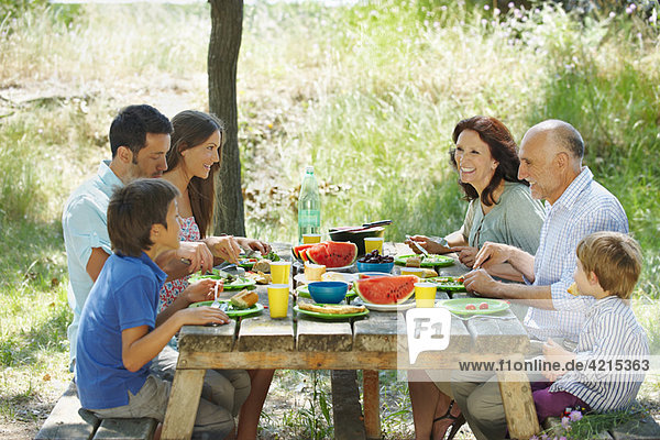 Family eating meal on outdoor table