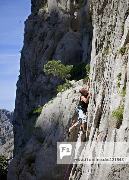 Rock climber climbing rock face