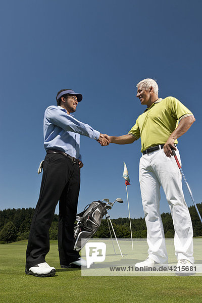 Golfer and caddy shaking hands