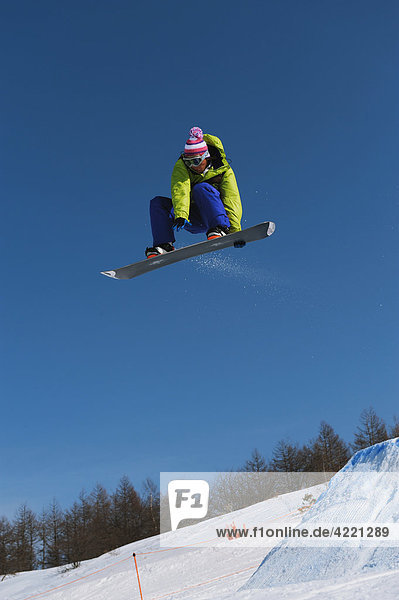 Snowboardfahrer In der Luft schwebend springen