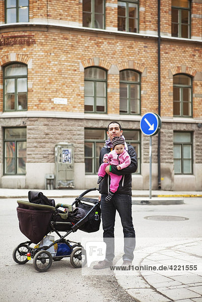 Vater und Tochter in der Innenstadt mit Kinderwagen