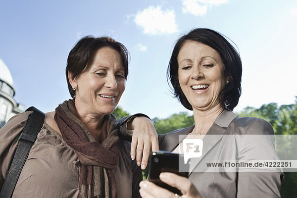 Two women looking at telephone
