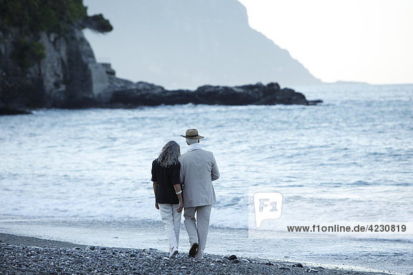 Seniorenpaar geht am Strand spazieren  Italien  Sori