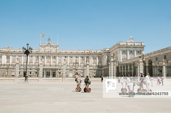 Royal Palace and group of tourists riding segways  Madrid  Spain
