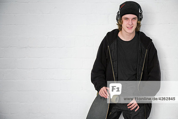 Portrait of teenage boy with skateboard