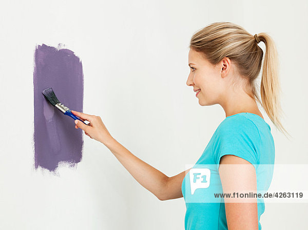 Junge Frau beim Malen einer Wand