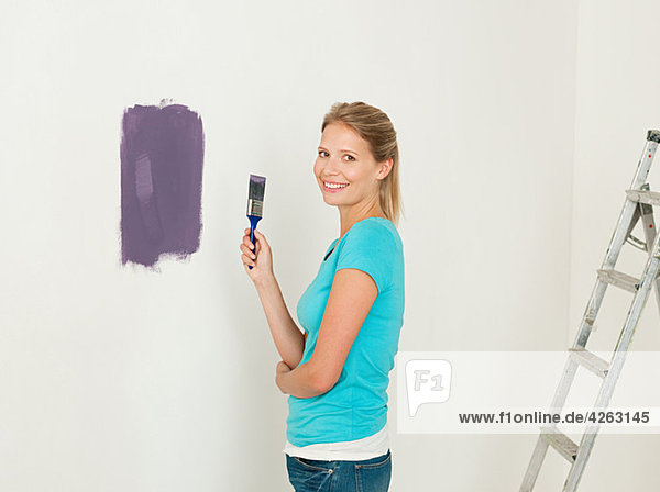 Junge Frau beim Malen einer Wand