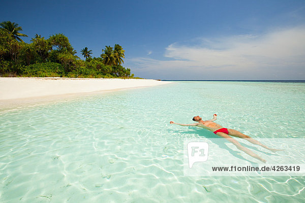 Im Meer schwimmender Mann  Insel Baughagello  Südliches Huvadhu Atoll  Malediven