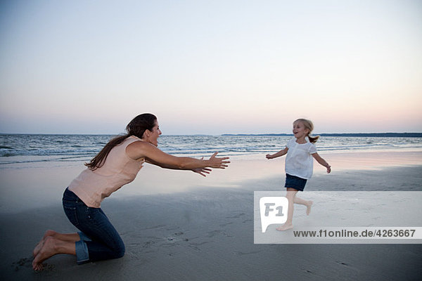 Girl running to mother on beach
