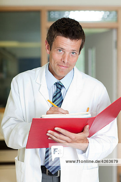 Doctor writing in folder