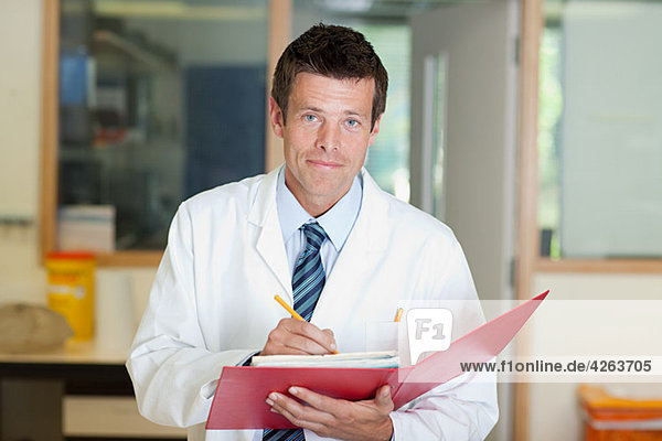 Doctor writing in folder