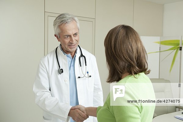 Doctor and female patient shaking hands