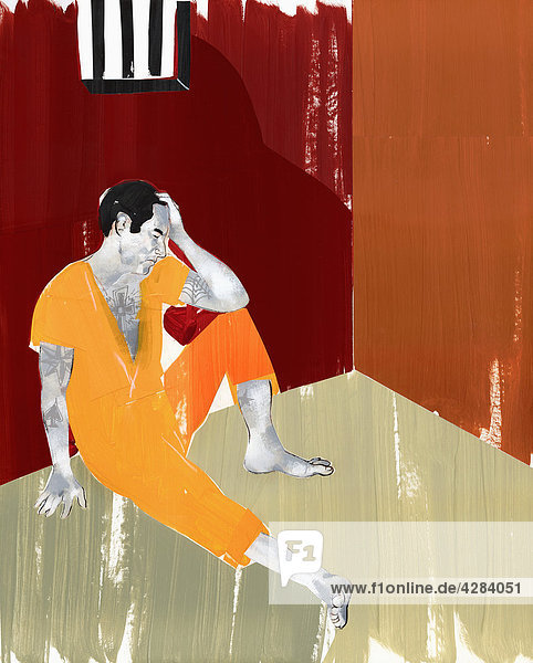 Mann sitzt auf dem Fußboden einer Gefängniszelle