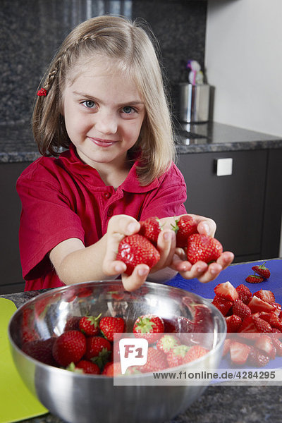 Mädchen beim Zubereiten von Erdbeeren