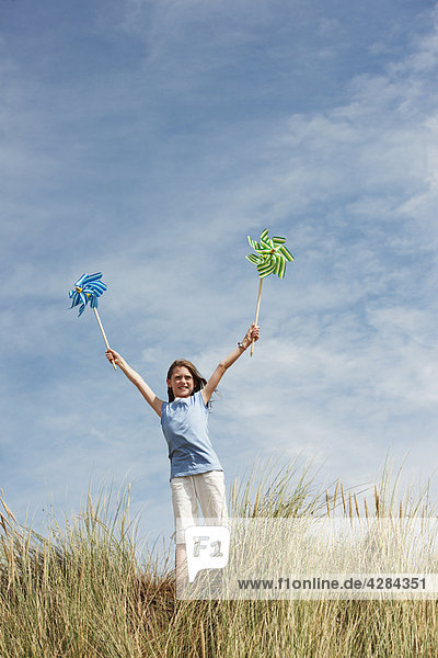 Girl Holding Windmühlen am Himmel