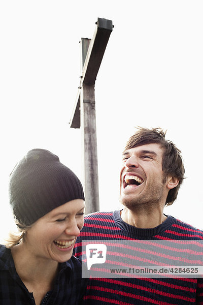 Couple laughing under mountain cross
