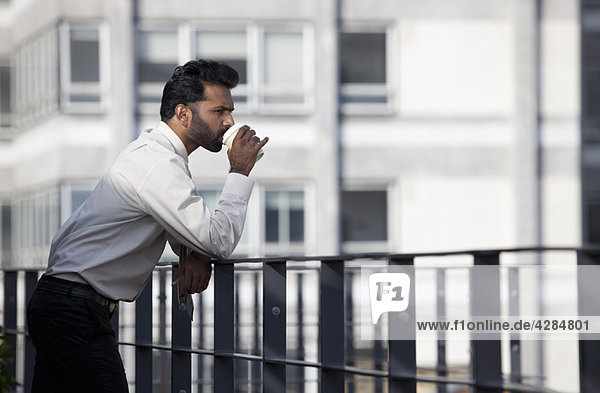 Businessman thinking and drinking coffee