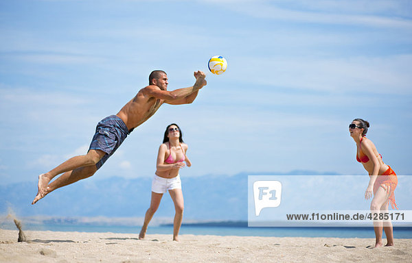 Freunde beim Volleyball am Strand