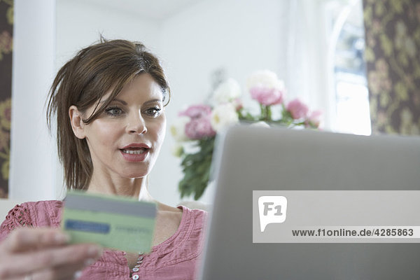 Frau am Laptop mit Kreditkarte