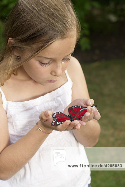 Young girl holding butterfly