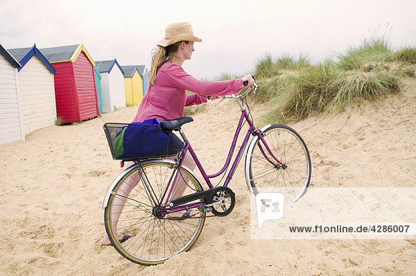 Frauen schieben Fahrrad über den Strand
