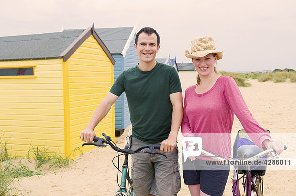 Happy couple on beach with bicycles