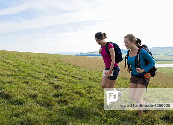 Female hikers climb hill