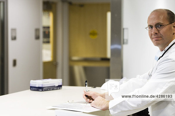 Doctor completing paperwork  portrait