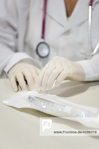 Healthcare worker opening sterile package containing medical supplies