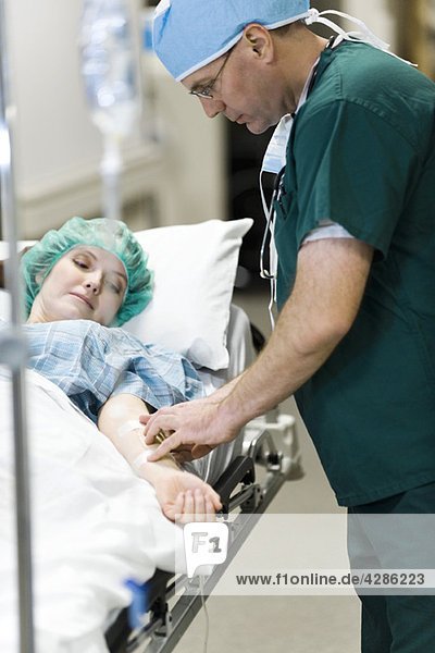 Krankenschwester beim Einführen der IV in den Arm des Patienten