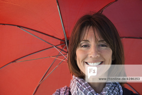 Reife Frau unter dem Schirm  Portrait