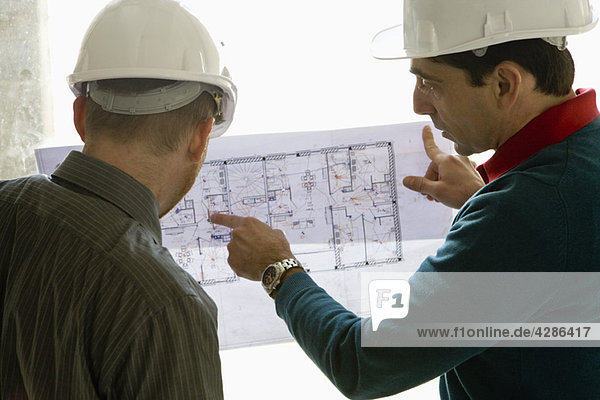 Bauunternehmer erklärt den Bauplan