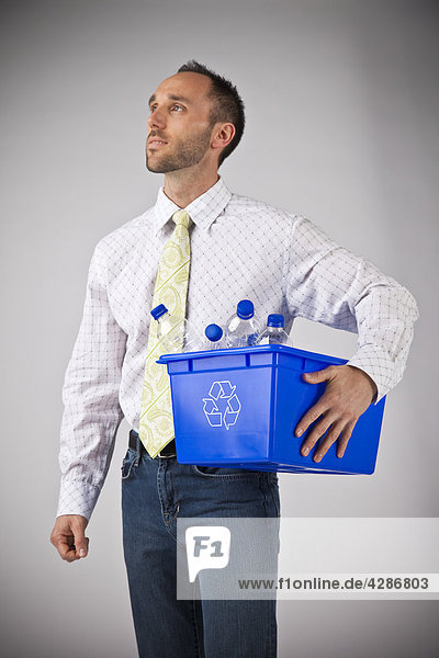 Geschäftsmann  der Recyclng bin hält mit Wasser-Flaschen gefüllt