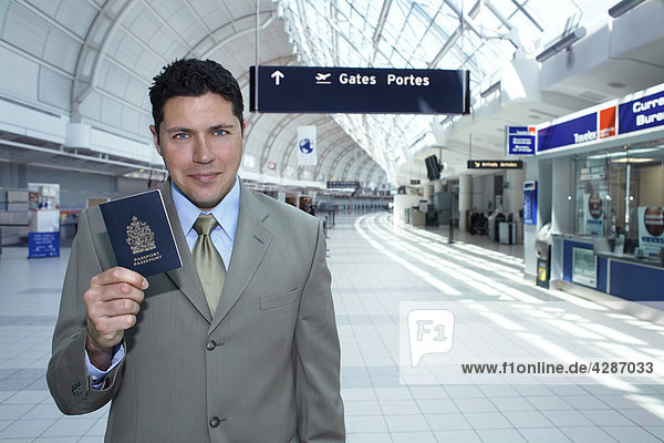 Businessman holding passport at airport  Toronto  Ontario  Canada