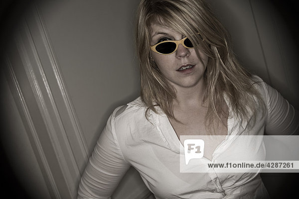 Junge blonde Frau in ihrer frühen 20 der Sonnenbrille tragen