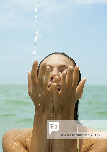 Frau im Meer  Spritzwasser mit den Händen  Nahaufnahme